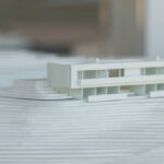 Atelier dos Remédios, Madalena Cardoso de Menezes, and Francisco Teixeira Bastos’ 18 Architectural Townhouses, Lot 215, showcasing a modern design with clean lines, a combination of glass façades and textured surfaces, and a cohesive arrangement of multiple townhouse units.