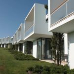 Gonçalo Cardoso de Menezes’ 21 Architectural Townhouses, Lot 154, showcasing modern urban design with multiple balconies, landscaped hedges, and integrated green spaces surrounding the villa-style homes.