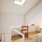 Eduardo Souto de Moura’s Convento das Bernardas Residence interior showcasing wooden flooring, minimalist furniture, high ceilings, and clean architectural lines.